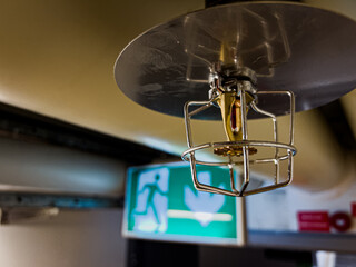a close up shot of a fire security sprinkler head covered with a safety basket and water spill...