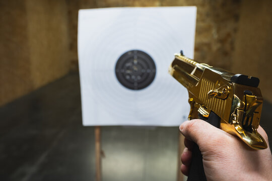 Shooting at a shooting range with a powerful golden  pistol.