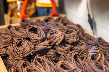 Italian food, dried handmade colorful pasta  tagliatelle with added cacao, ready to cook, Milan,...