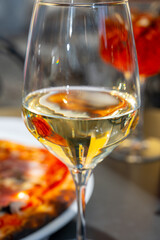 Glass of cold dry white wine served outdoor in cafe in Bellagio, Como lake, Italy