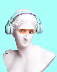 Antique statue bust with human eye photo elements expressing shock, wearing headphones on blue background. Modern design. Contemporary colorful art collage. Concept of creative vision, emotions.