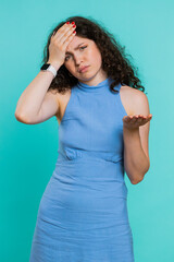 Face palm. Shame on you. Upset Caucasian young woman making face palm gesture, feeling bored, disappointed in result, bad news, sorrowful. Unhappy girl isolated on blue background indoors. Vertical
