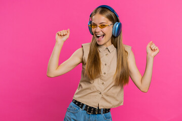 Happy woman in headphones listening music and dancing disco fooling around having fun expressive...