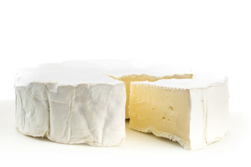 closeup of a round of brie cheese with a wedge cut out on white