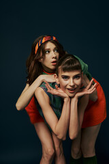 Two women in casual attire strike a pose together.