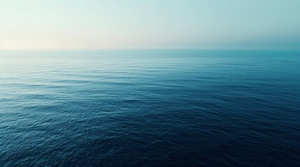 An aerial view of a calm sea at dawn, the subtle gradient of blues creating a tranquil, minimalist landscape that invites contemplation. - obrazy, fototapety, plakaty