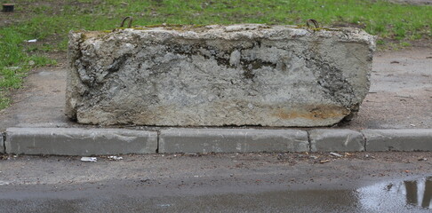 An old broken concrete block blocks the entrance to the sidewalk