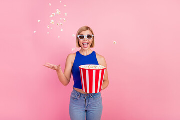Photo of pretty young woman 3d glasses movie throw pop corn wear blue top isolated on pink color...