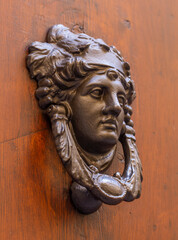 Vintage metal door knocker with a human face.