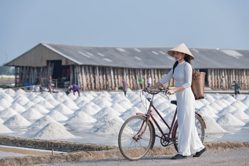 person riding a bike.  Woman with bike. Asian woman (Vietnams)  with Bicycle in the Salt farm.