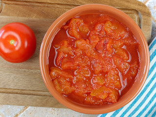 bol de tomates concassées, en gros plan, sur une planche à découper	