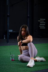 Mexican female athlete taking a break, looking at her smart watch after her workout
