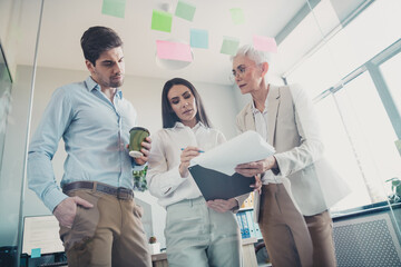 Photo of business people hold clipboard reading write analytics in workstation