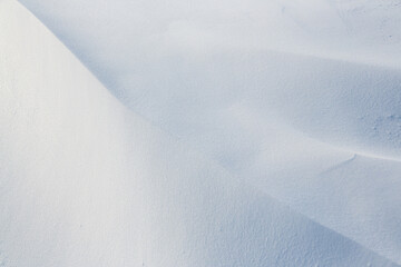 Beautiful winter background with snowy ground. Natural snow texture. Wind sculpted patterns on snow surface. - 794084779