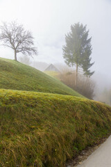 Foggy landscape in the early morning. Green mountains covered with thick fog