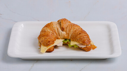 Croissant sandwich on plate isolated on white