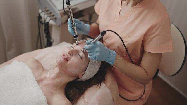 A client enjoys a relaxing microcurrent facial therapy administered by a professional aesthetician in a spa setting, enhancing skin rejuvenation.
