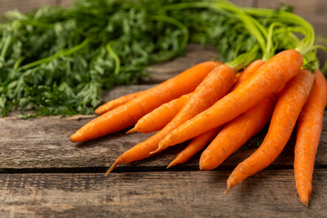Carrots on a textured wooden background. Fresh and sweet organic carrots on a white background. Carrot slices. Vegan. Ingredients for salad. Place for text. Copy space. Flatley