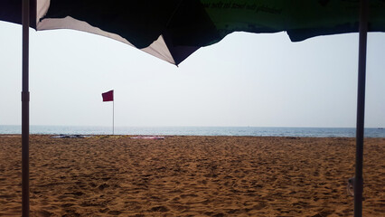 beach view with red flag and sand texture front tent view