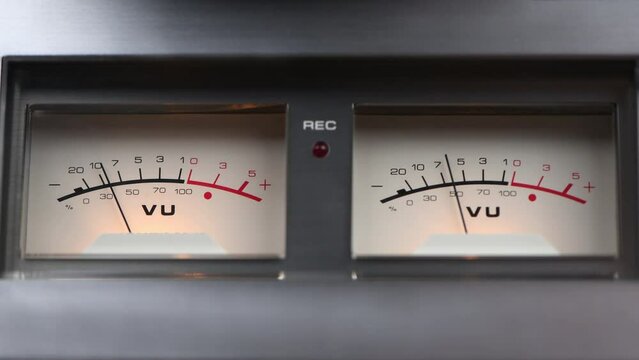 Analog recording level indicators on a reel-to-reel tape recorder in 4k. Close-up analog signal indicator with arrow