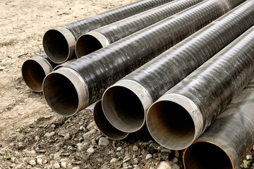 Close-up of a lot of large iron pipes for water supply.