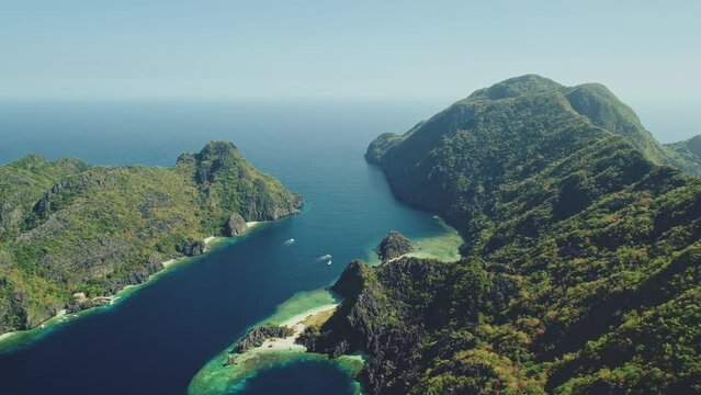 Green mountain islands at sea bay coast aerial view. Ocean islets seascape of tropical forest at hilly islands of El Nido, Philippines. Nature scenery of blue ocean water at summer sunny day