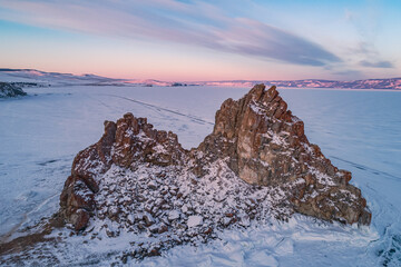 Aerial shot of a Shamanka rock on Olkhon island at sunset. Winter landscape. Popular touristic...