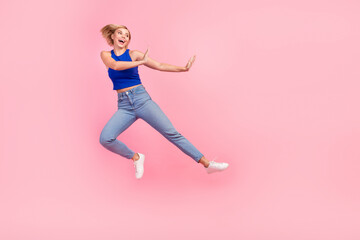 Fototapeta na wymiar Full body portrait of nice girl jump fight kick empty space wear blue top isolated on pink color background