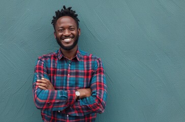 Smiling Young Man with Arms Crossed Against Green Background