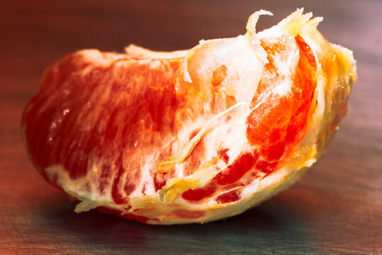 Piece of ripe red grapefruit macro view