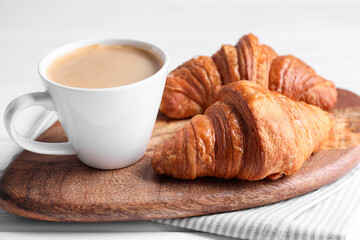 Tasty breakfast. Cup of coffee and croissants on table, closeup