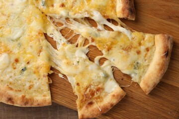 Delicious cut cheese pizza on wooden table, top view