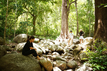 Group of three Asian friends, two men and one woman, have a good relationship, hiking at the...