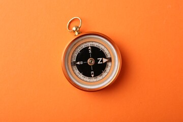 One compass on orange background, top view