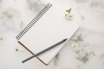 Guest list. Notebook, pencil and beautiful cherry tree blossoms on spring floral background, flat lay