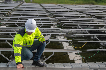 Engineer working at floating solar farm,checking and maintenance with solar batteries near solar...