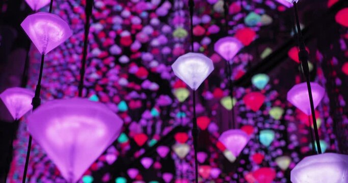 A close-up of glowing multicolored shapes in a light labyrinth installation