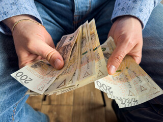 man holds a large bundle of polish money zloty pln zl