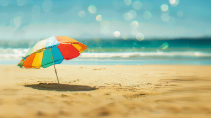 Colorful beach umbrella on sandy shore with sun flare