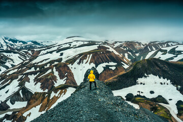 Female hiker standing on Blanhjukur trail with volcanic mountain in moody day at Icelandy at...