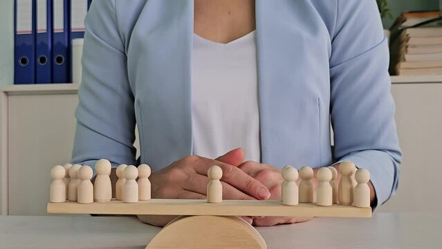 The leader stands on a scale between two groups of people. Conflict resolution
