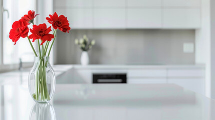 A sleek kitchen with all white appliances and a splash of red from a single vase of flowers. . .