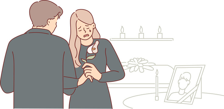 Widow woman cries at funeral standing near table with portrait of deceased husband at mourning event. Guest expresses condolences to distressed widow in need of support due to death of loved one