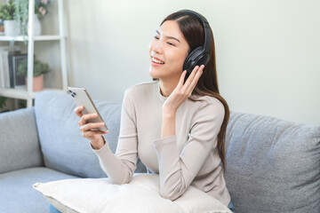 Relaxing asian young woman using smart phone listening to music, enjoy song or watching videos,...