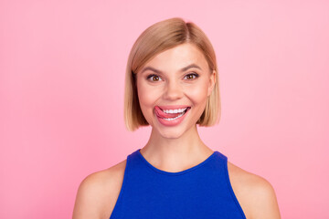Portrait of nice girl tongue lick teeth empty space wear blue top isolated on pink color background