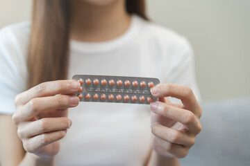 Contraception and pregnancy, menstruation concept, birth control pills asian young woman hand...