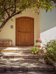 A contemporary design house entrance with an arched wooden door by a green garden. Travel to...