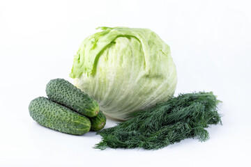 Cucumbers, greens and iceberg lettuce on a white background.