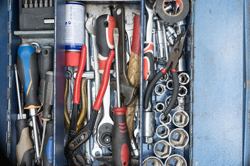 Detail of the tools in an old two-tier metal toolbox. Amount of tools in an old worn box....