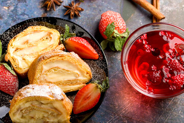 Sliced rolls with custard. The dessert is decorated with fresh strawberries